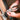 Person using pliers on a metal bracket with a wooden surface in the background