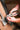 Person using pliers on a metal bracket with a wooden surface in the background
