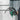 Person using a tool on a metal wall with a ladder in the background