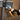 Person wearing gloves using pliers to work on electrical wiring in a metal box.