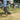Person using a device on grass with a Klein Tools toolbox in the background