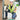 A construction worker wearing a white hard hat, safety vest, and knee pads kneels on a concrete floor, handling a green cable next to an electrical panel in a workshop setting.